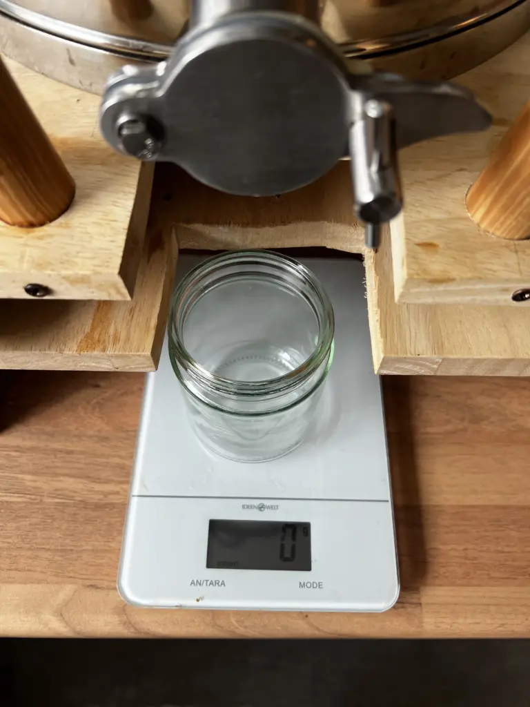 Husener Honighandwerk: Abfüllhobock mit Neutralglas auf Waage